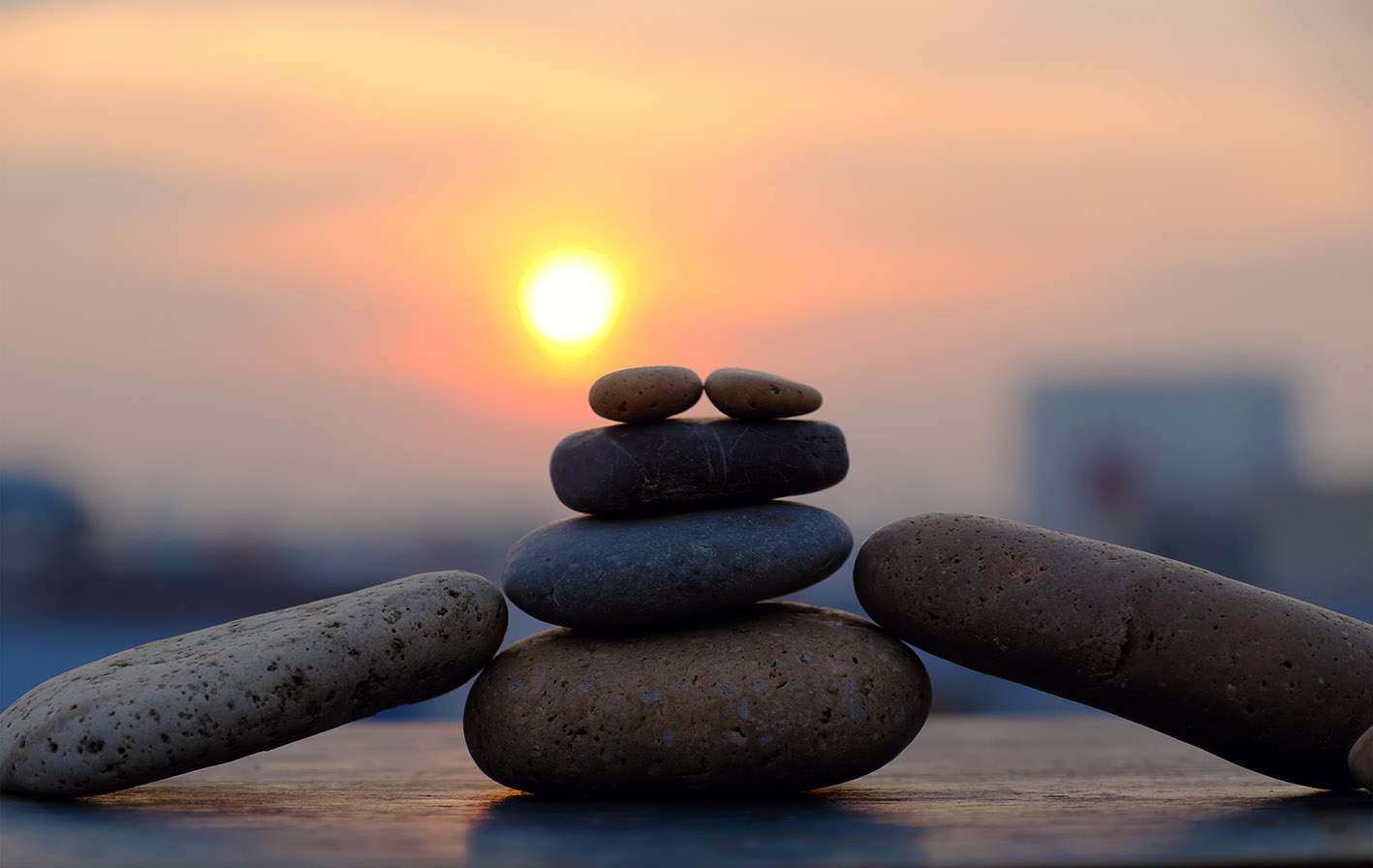 Στοίβα από βότσαλα μεγάλα και μικρά που ισορροπούν. Ηλιοβασίλεμα