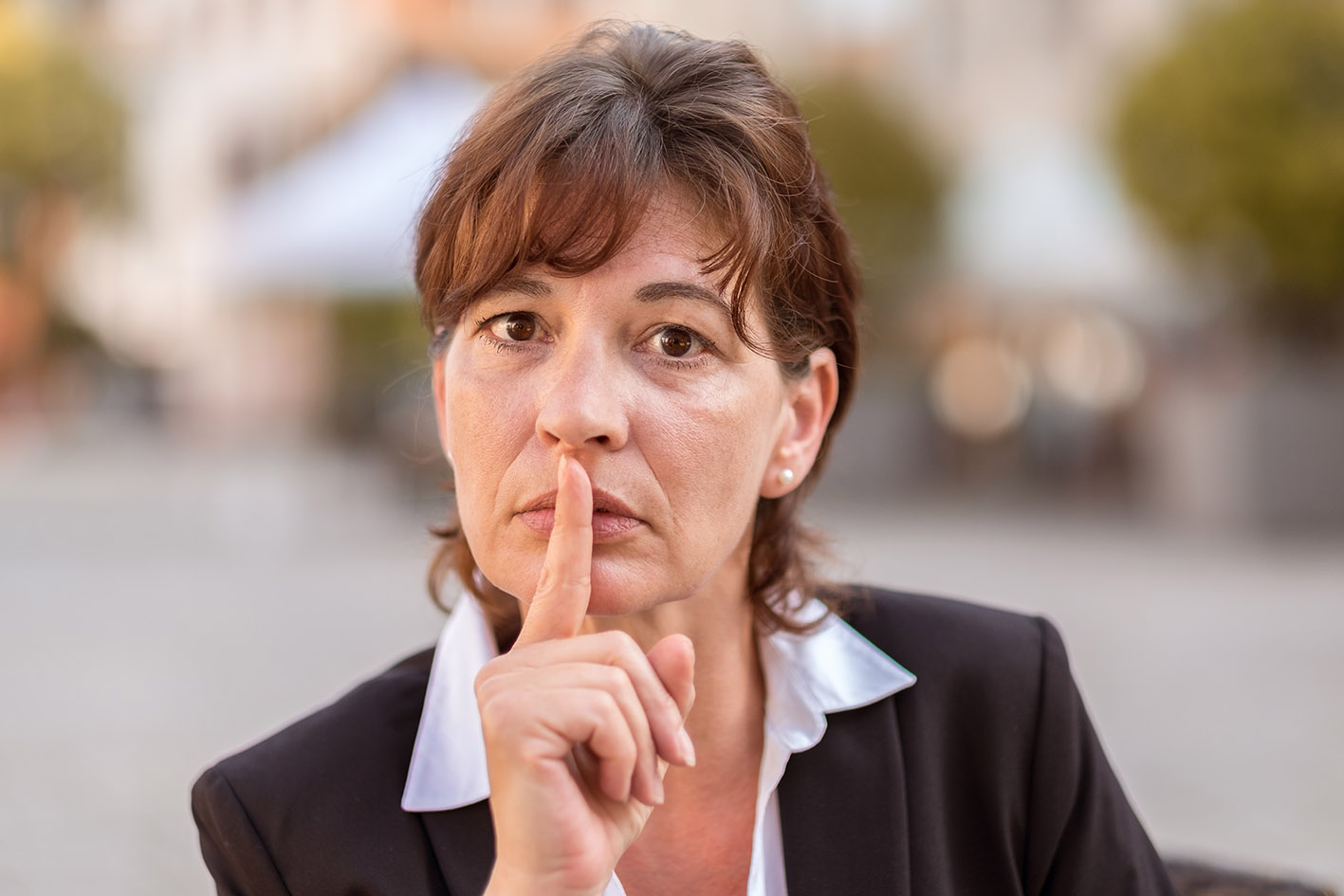 Γυναίκα με το χέρι της να κάνει το σήμα μη μιλάς