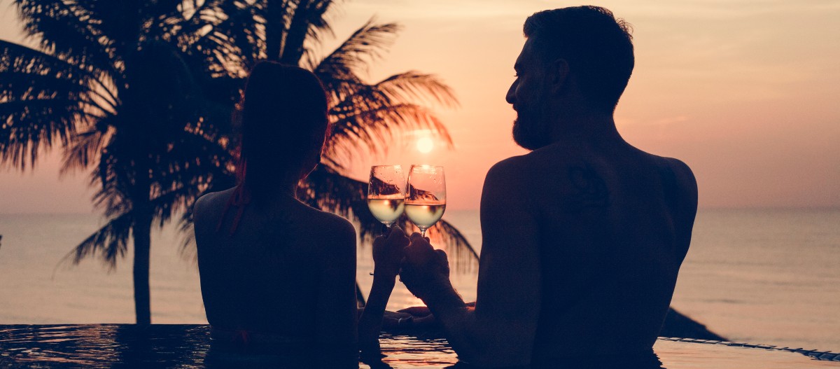 Καλοκαιρινός έρωτας, ζευγάρι πίνει κρασί μέσα σε πισίνα