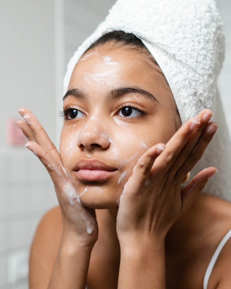 Γυναίκα που καθαρίζει με αφρό το πρόσωπό της