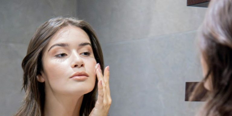 Γυναίκα κοιτάζει στον καθρέφτη του μπάνιου