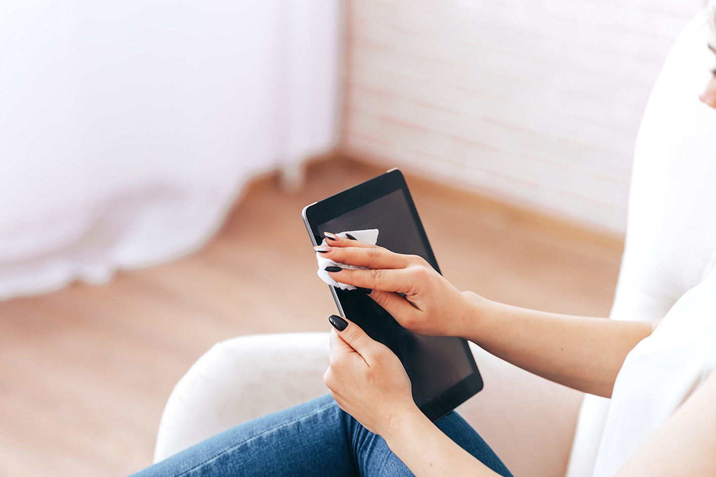 Γυναικεία χέρια καθαρίζουν κινητό με μωρομάντηλα