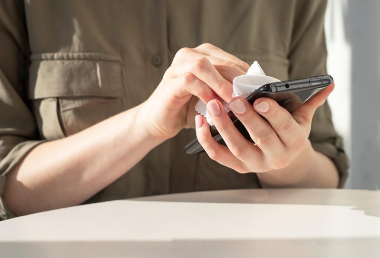 Γυναικεία χέρια καθαρίζουν κινητό με μωρομάντηλα