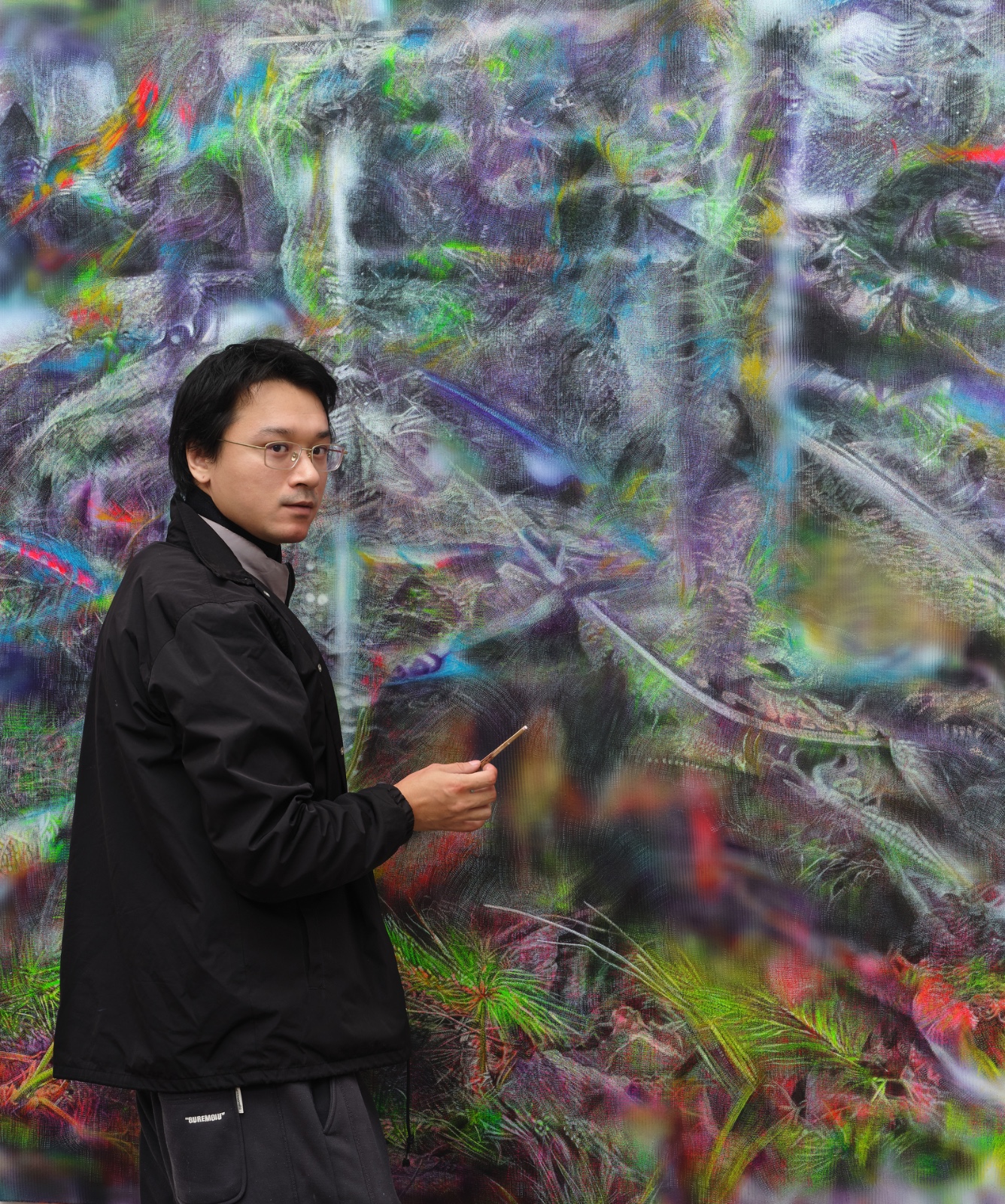 O καλλιτέχνης Bai Yiy μπροστά από έργο του.