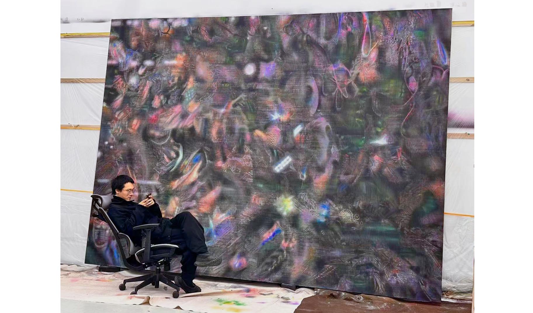 O καλλιτέχνης Bai Yiy μπροστά από έργο του.