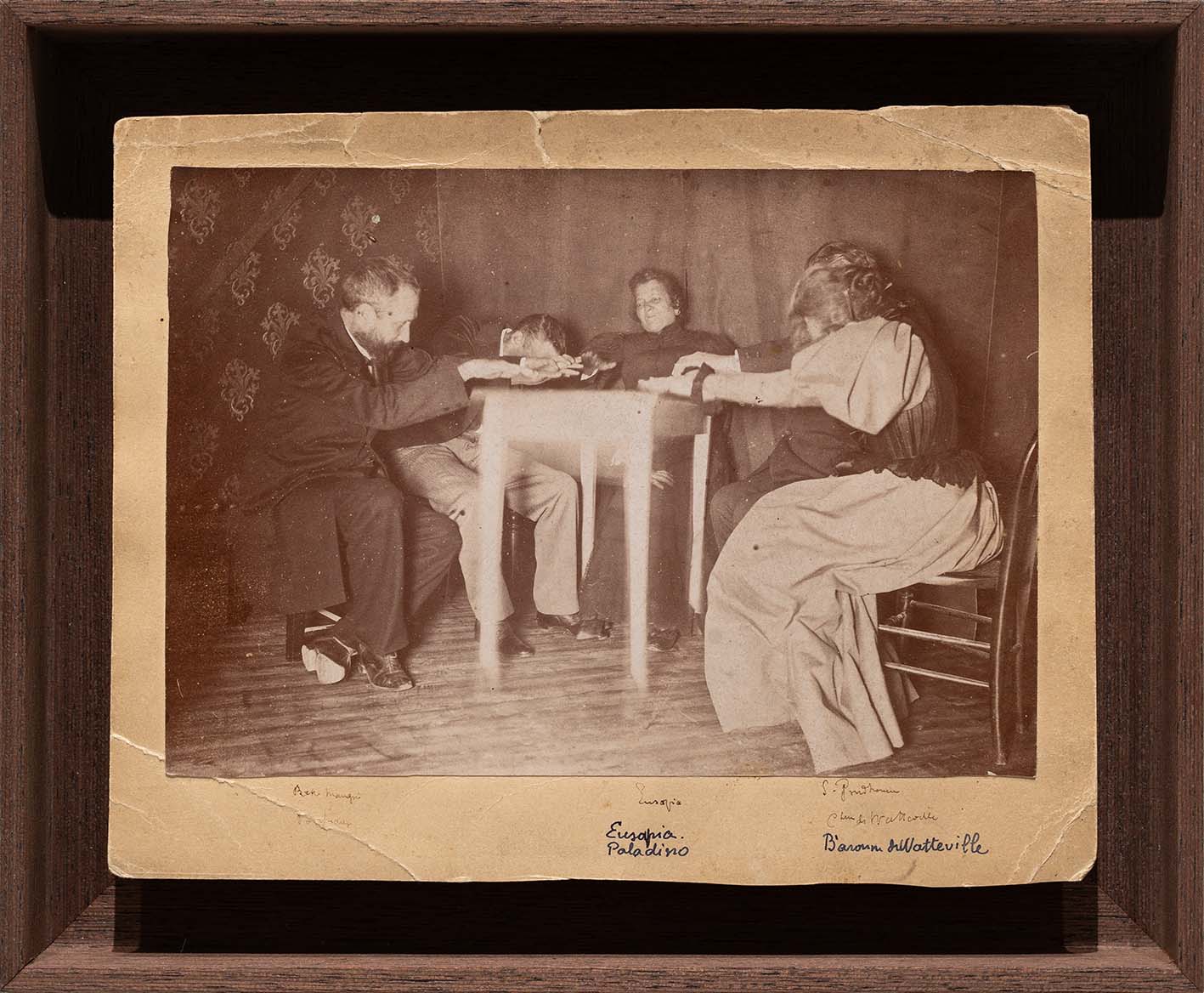 Eusapia Palladino - Seduta con la medium Eusapia Palladino. Alla presenza di Sally Proudhomme e della Baronessa de Watteville, tra gli altri, 1985-1900 - Annotazioni con inchiostro sotto l’immagine. - Didascalia in matita nera sul verso del supporto. - Stampa alla gelatina d’argento montata su cartone
11,9 x 17 cm; 14,8 x 19,3 cm foglio; 19,5 x 23,2 x 3,5 cm con cornice