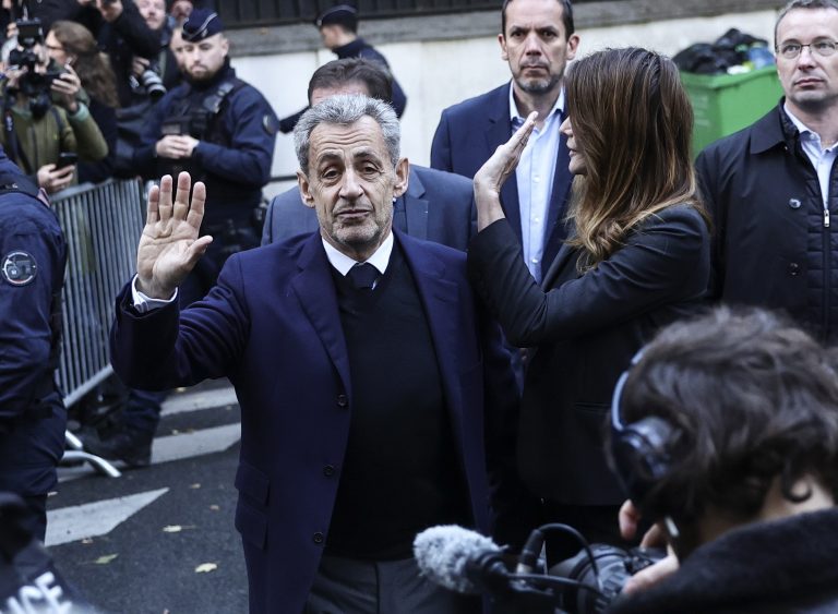 O Nicolas Sarkozy και η σύζυγός του, Carla Bruni χαιρετούν το συγκεντρωμένο πλήθος την ημέρα που αναμενόταν να μπει στη φυλακή, στις 21 Οκτωβρίου 2025