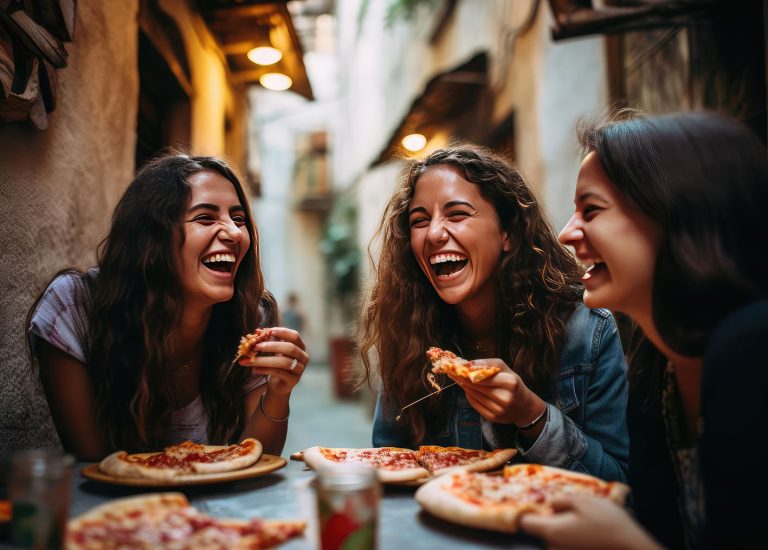 Παρέα κοριτσιών τρώνε πίτσα και γελάνε