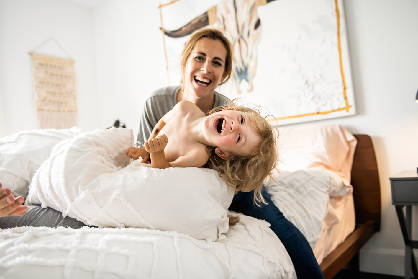 Μαμά παίζει με την κόρη της και την γαργαλά.