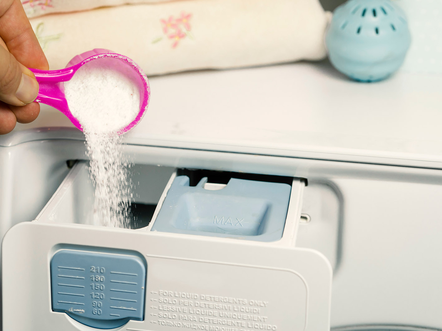 Σκόνη πλυντηρίου ρίχνεται με μεζούρα στη θήκη του πλυντηρίου