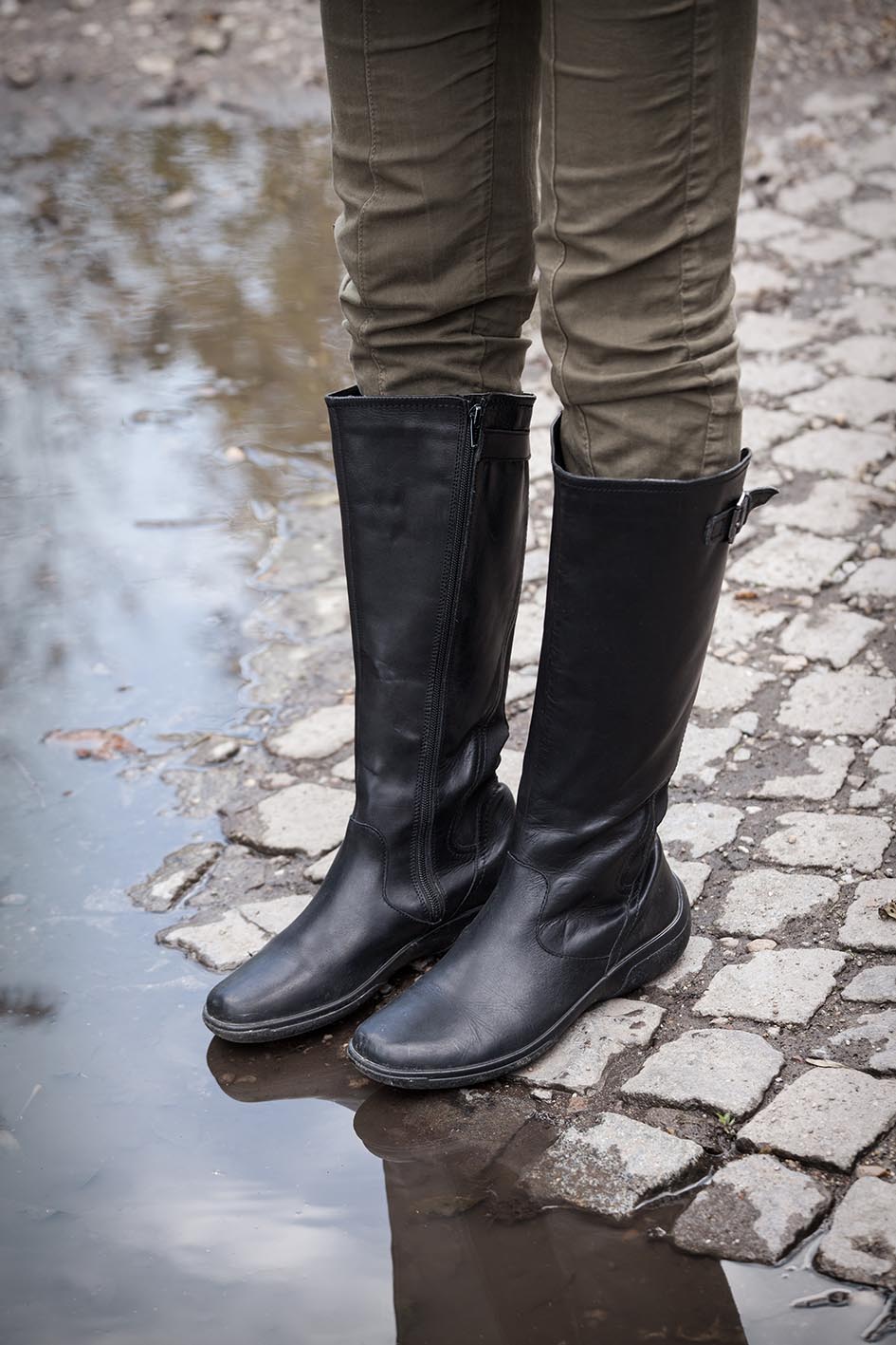 Γυναίκα με ψηλές μαύρες μπότες σε βροχερή μέρα