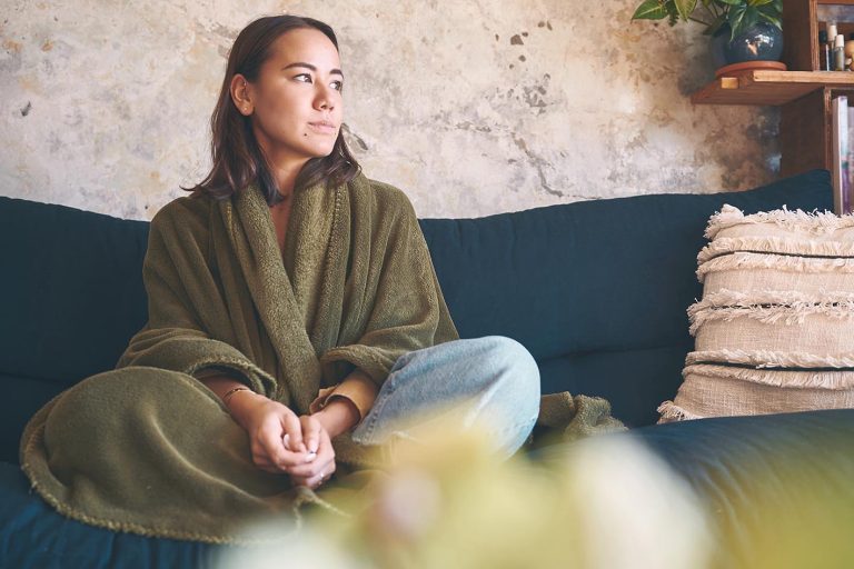 Γυναίκα ήρεμη στον καναπέ του σπιτιού της