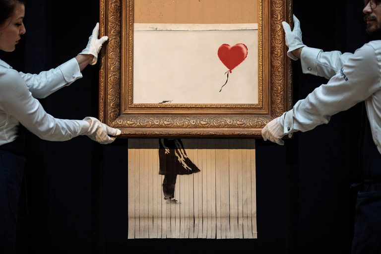 Οι υπάλληλοι του οίκου Sotheby's ποζάρουν με το έργο Love is in the Bin «Η αγάπη είναι στον κάδο» του Βρετανού καλλιτέχνη Banksy στις 12 Οκτωβρίου 2018 στο Λονδίνο.