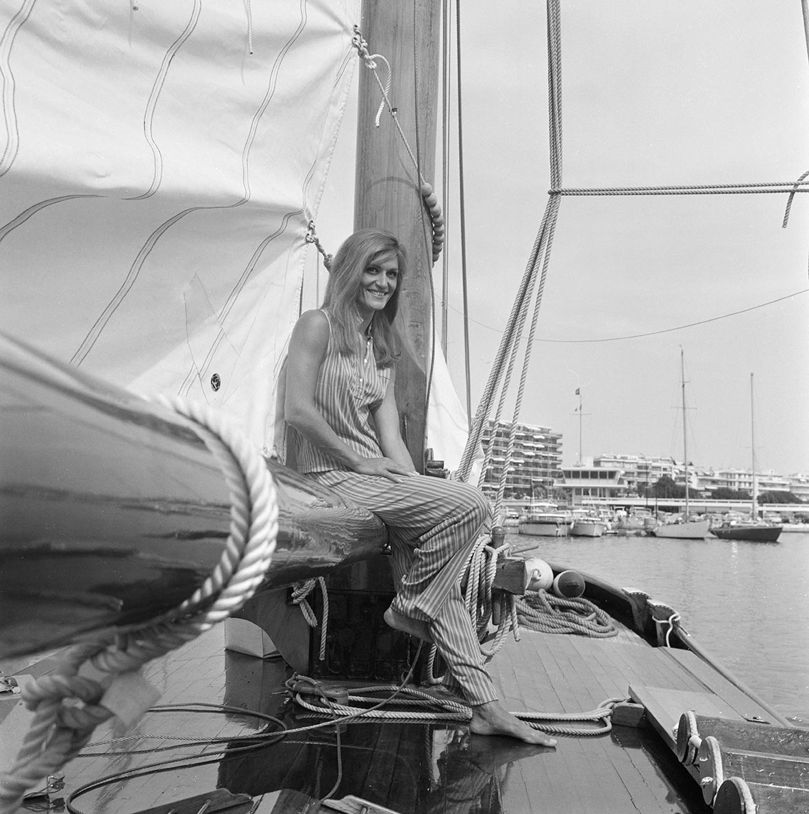 H Dalida καθισμένη στο κιγκλίδωμα ενός σκάφους στο λιμάνι των Καννών, στη Γαλλία, στις 21 Ιουλίου 1966.