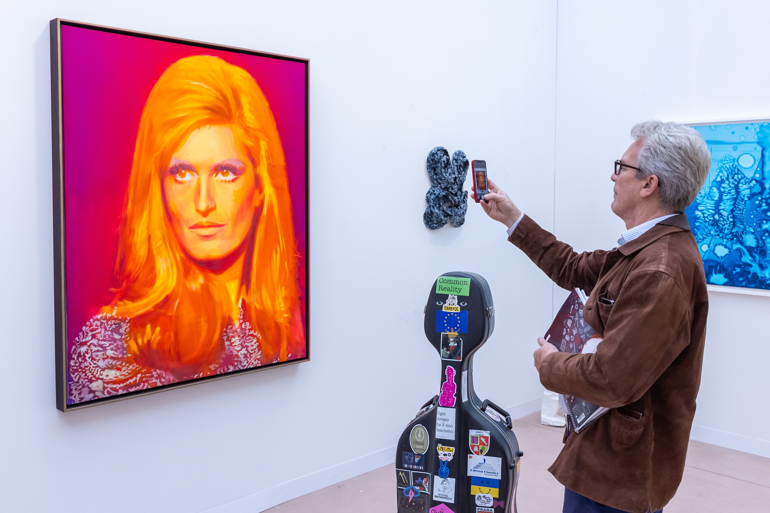 Ένας επισκέπτης φωτογραφίζει μια αφίσα με την αείμνηστη Dalida, που δημιουργήθηκε από τη Γαλλοαμερικανίδα καλλιτέχνιδα Nina Childress και εκτίθεται στη διεθνή έκθεση τέχνης Art Basel στο Παρίσι, 17 Οκτωβρίου 2024