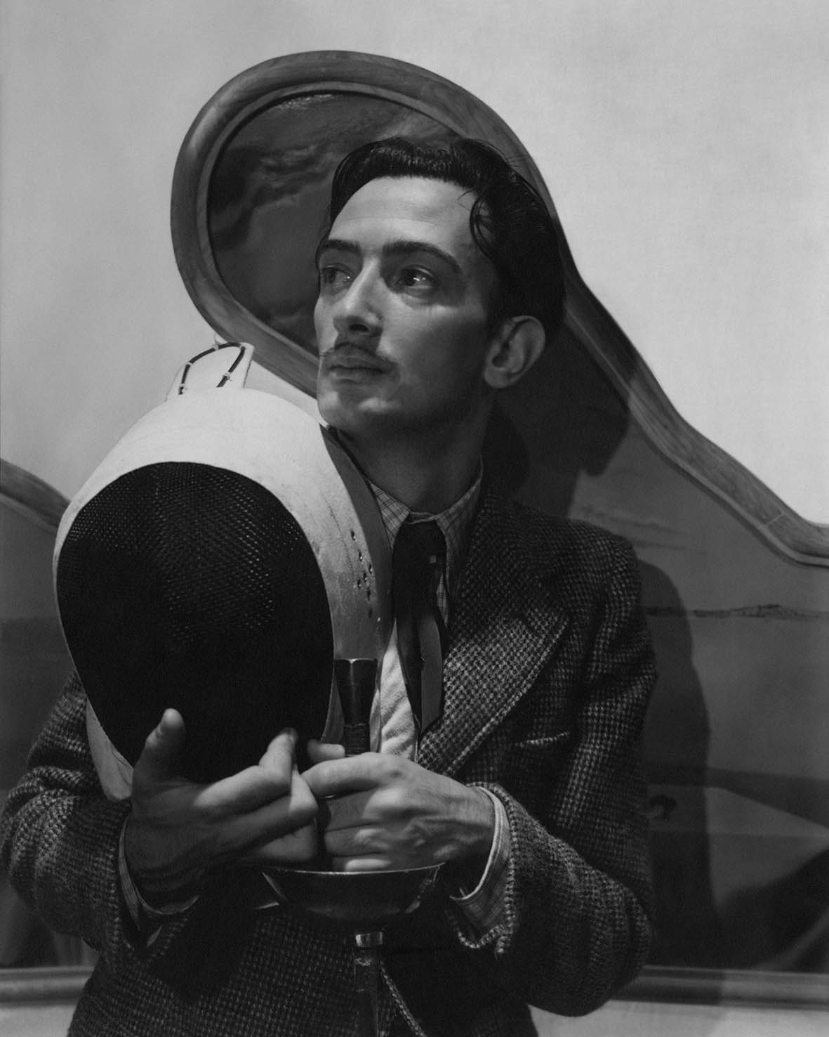 O Salvador Dali, κοιτάζοντας προς τη μία πλευρά, κρατώντας εξοπλισμό ξιφασκίας, φωτογραφημένος από τον Cecil Beaton για τη Vogue 1936. 