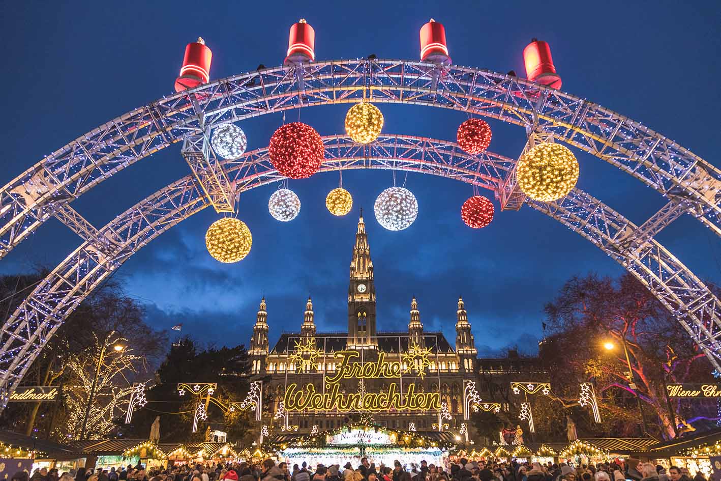 Tο εξωτερικό της χριστουγεννιάτικης αγοράς στο Rathaus στη Βιέννη τη νύχτα. πάγκοι στην αγορά και πολλοί τουρίστες και ντόπιοι.