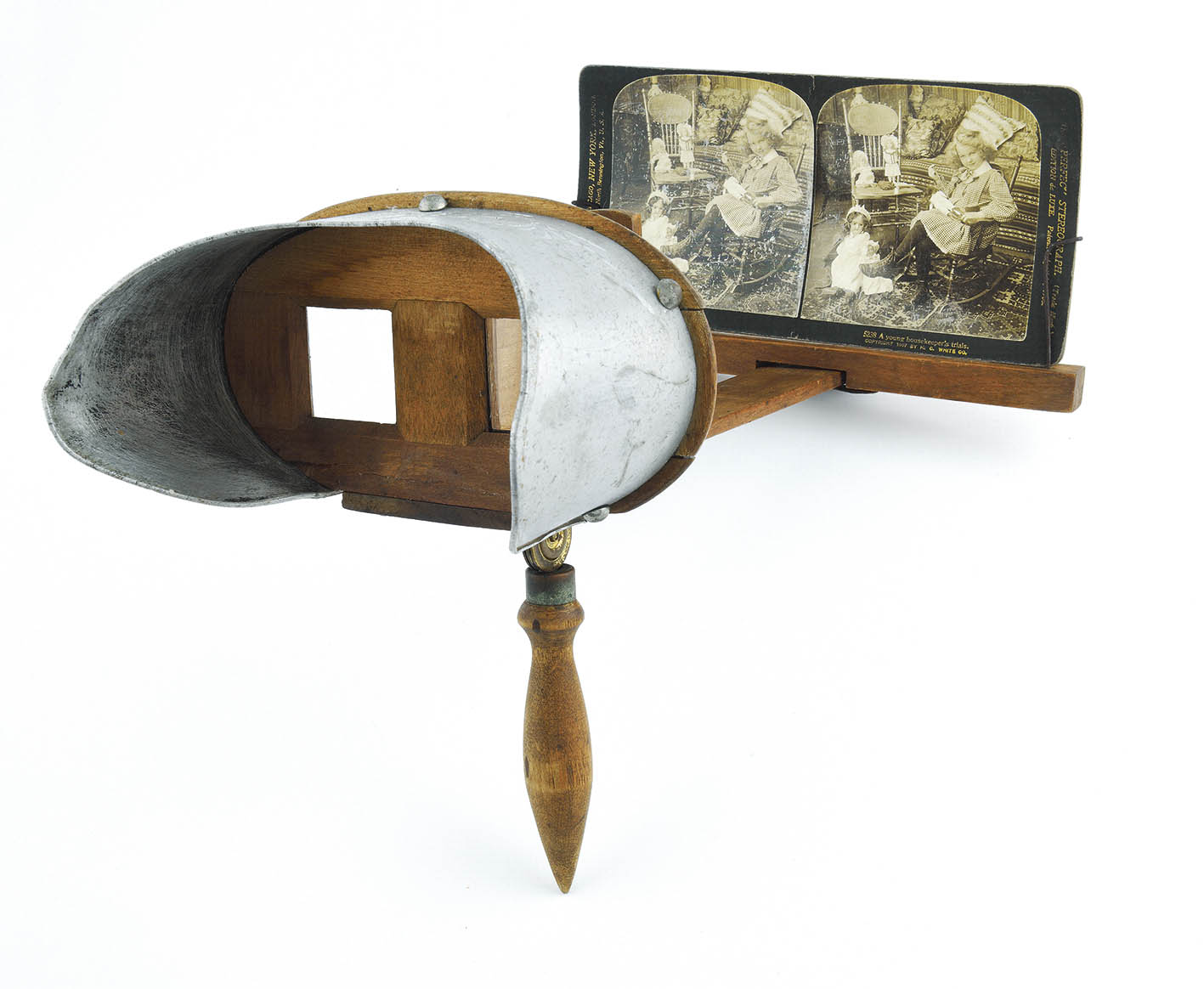 Στερεοσκόπιο με κάρτα «A young housekeeper’s trial”, H.C.WHITE.CO, PERFESCOPE • 1895-1902 • 22x33x19 εκ. (στερεοσκόπιο), 8,8x17,7 εκ. (κάρτα) • Μουσείο Μπενάκη, ΤΠΠ_6199 και ΤΠΠ_6200, δωρεά Μαρίας Αργυριάδη.