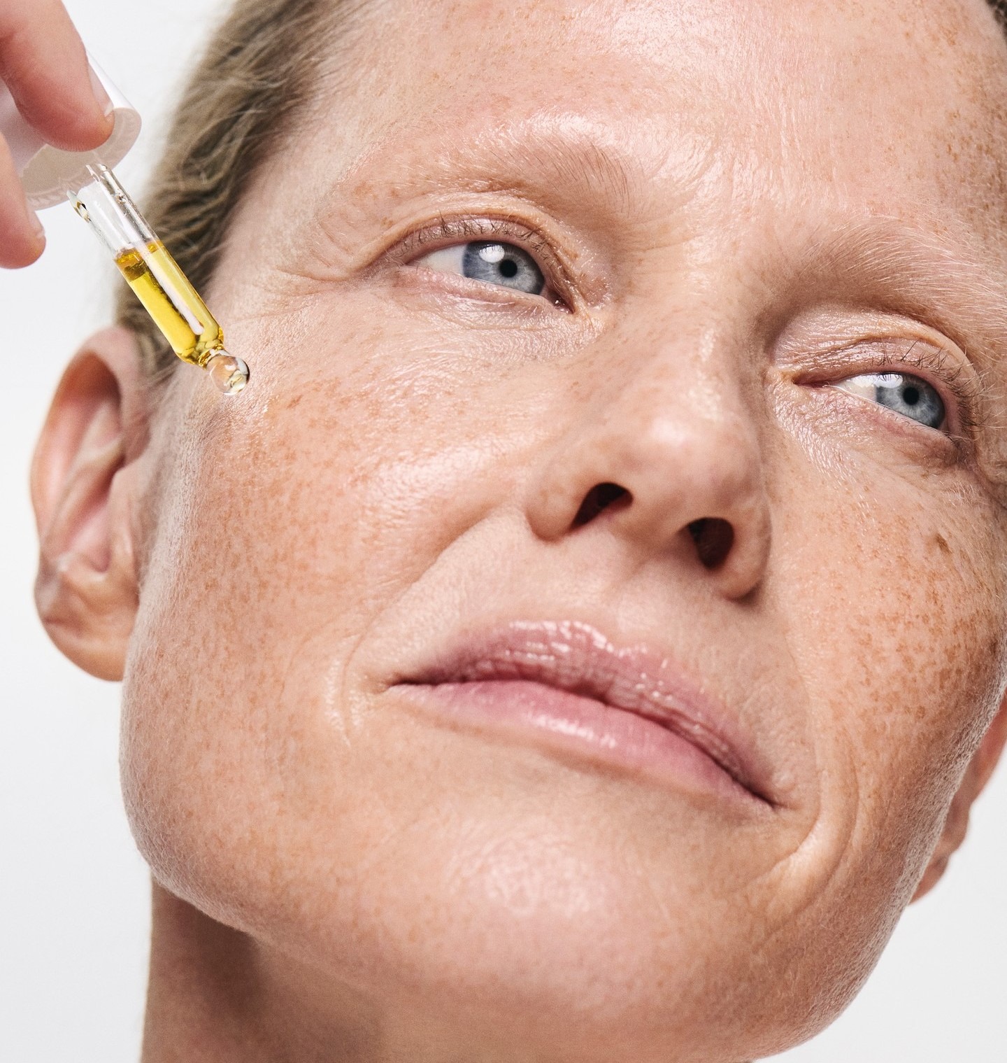 Γυναίκα βάζει έλαιο στο πρόσωπο