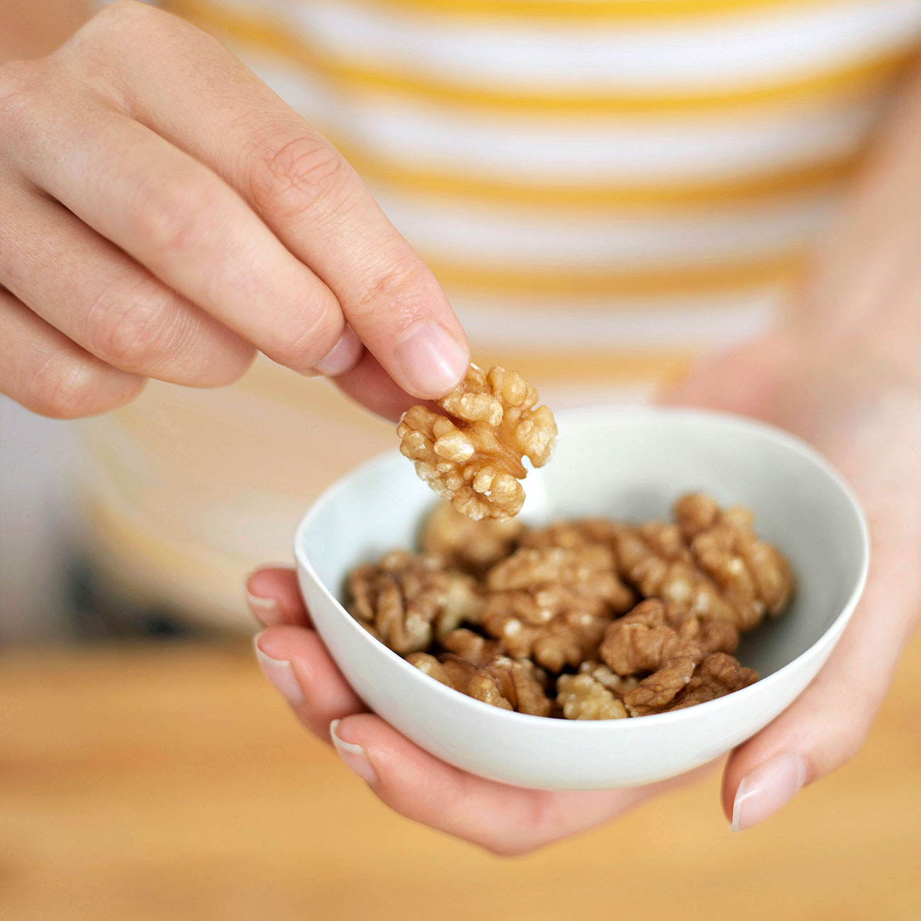 Γυναικείο χέρι παίρνει ένα καρύδι από μπολ