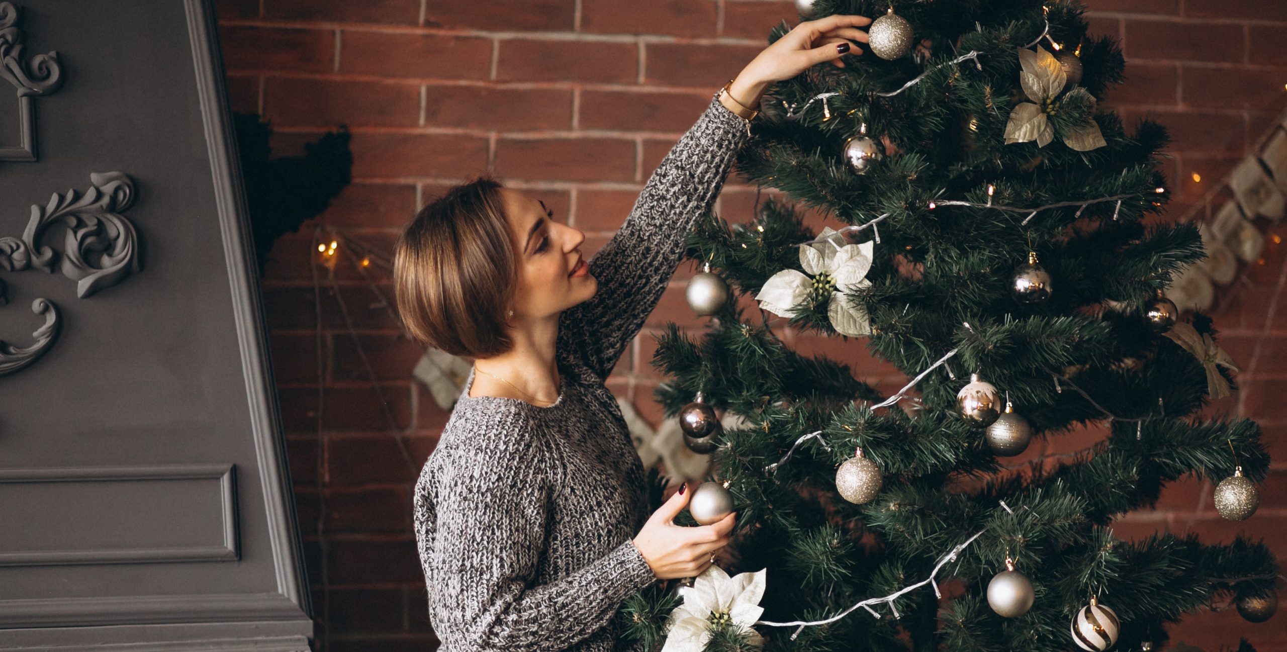 Γυναίκα στολίζει χριστουγεννιάτικο δέντρο