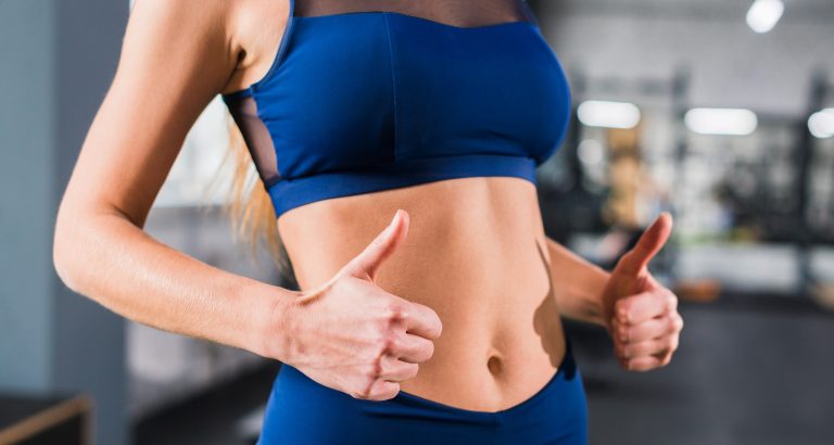 Γυναίκα στο γυμναστήριο. Κοντινό πλάνο στη γυμνή κοιλιά της