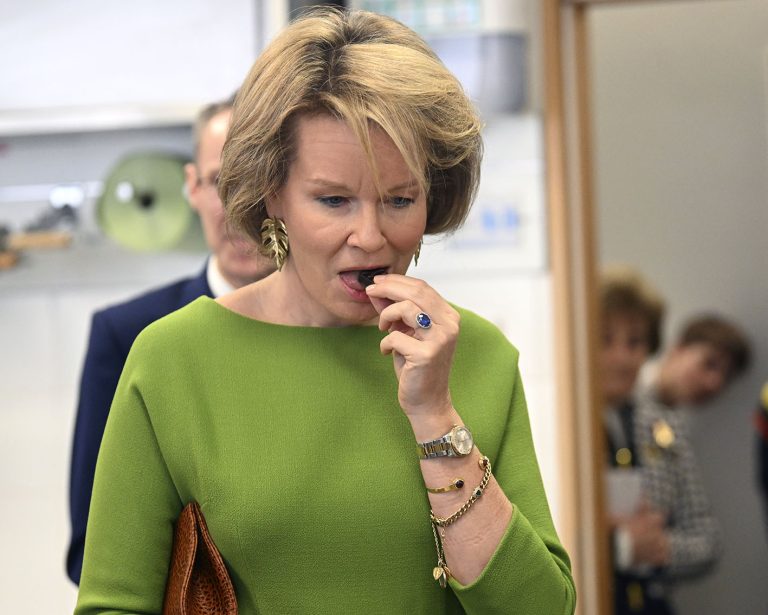 H Bασίλισσα Mathilde τρώγοντας ένα κομμάτι σοκολάτα στις 29 Μαρτίου 2024 σε επίσκεψή της στη Σχολή Ξενοδοχείων της Γάνδης.