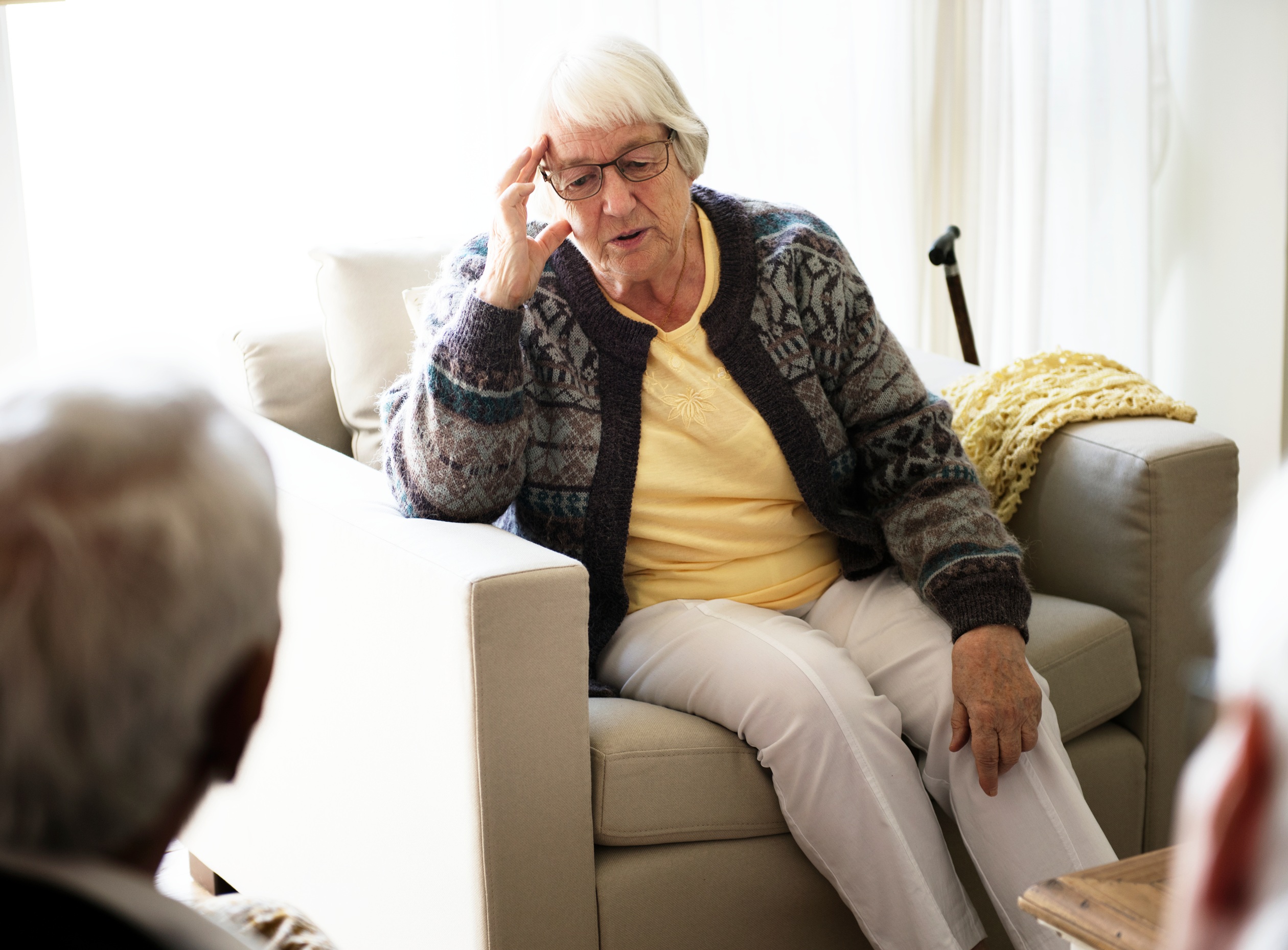Γυναίκα μεγάλης ηλικίας κάθεται σε καναπέ και μιλά με γιατρό