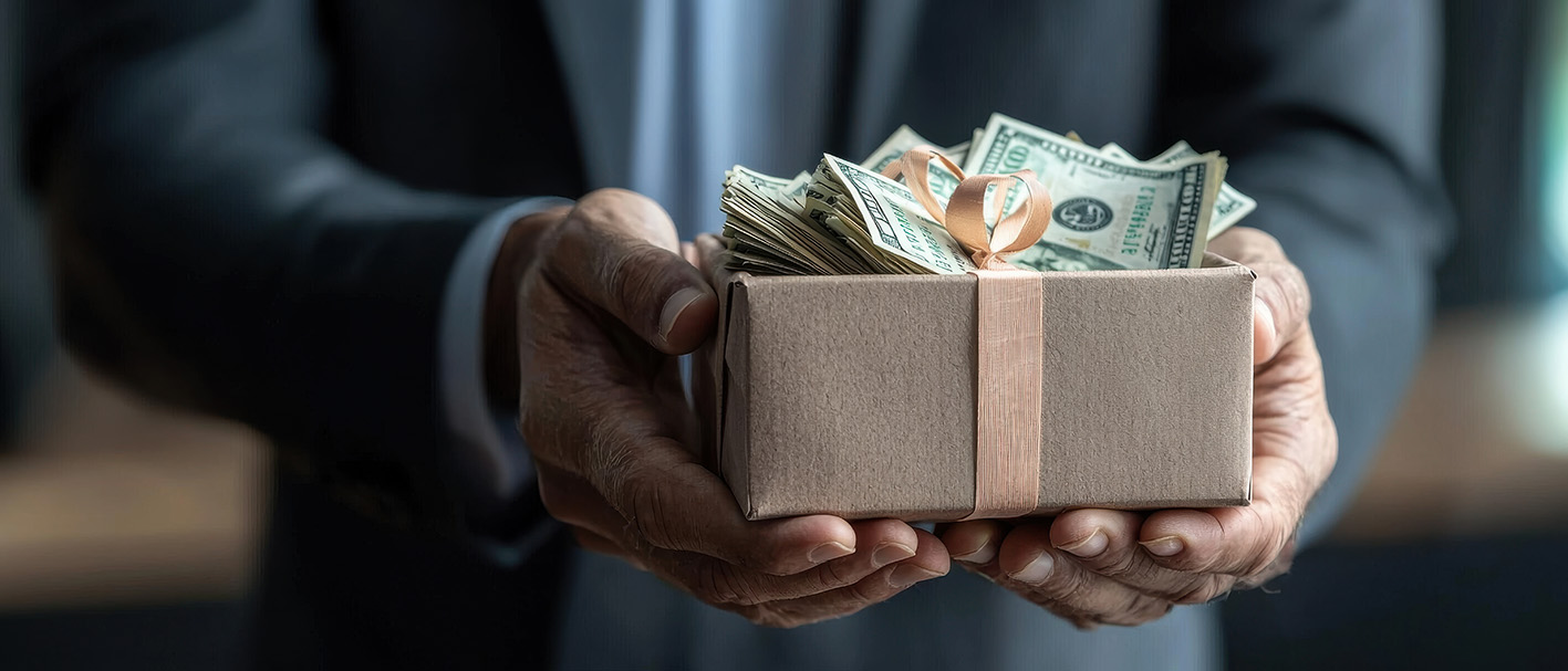 Άντρας κρατά κουτί με δολάρια για δώρο