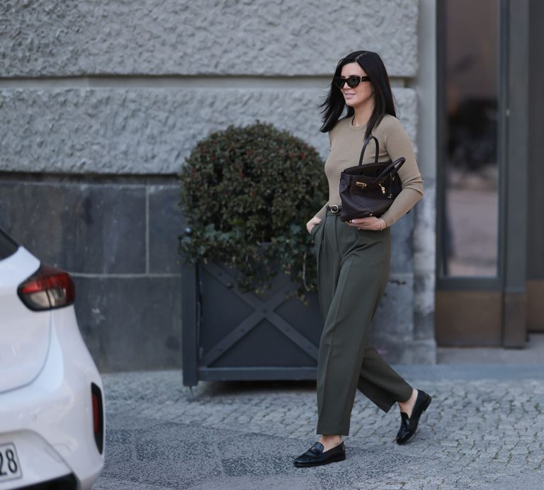 Η Leo Eberlin φορώντας oversized μαύρα γυαλιά ηλίου Yves Saint Laurent, κοσμήματα με διαμάντια Leo Mathild, εφαρμοστό, πλεκτό μακρυμάνικο πουλόβερ Arket με κλασική λαιμόκοψη σε ζεστό γκρι χρώμα, ψηλόμεσο, μακρύ, ελαφρώς φαρδύ παντελόνι Arket σε σκούρο λαδί χρώμα, μπορντό δερμάτινη ζώνη Yves Saint Laurent, κίτρινο χρυσό ρολόι Audemars Piguet, σκούρα καφέ τσάντα Birkin Hermès και μαύρα δερμάτινα μοκασίνια Chanel με γυαλιστερό φινίρισμα, στις 2 Απριλίου 2025 στο Βερολίνο της Γερμανίας.