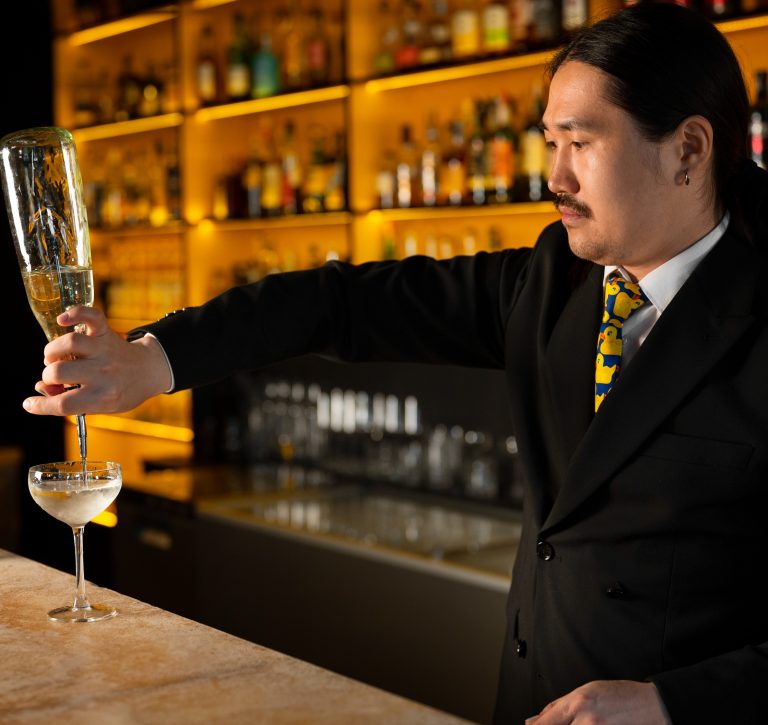 Μπάρμαν σερβίρει ποτό σε μπαρ.