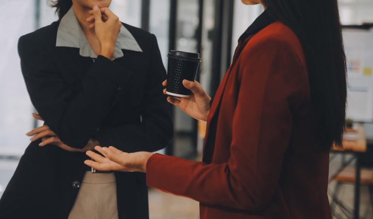 Συνάδελφοι στο γραφείο συζητούν. Βλέπουμε τα χέρια τους μόνο.