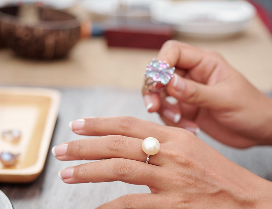 Γυναίκα δοκιμάζει δαχτυλίδι με πέρλες και με διαμάντι για δαχτυλίδι αρραβώνα
