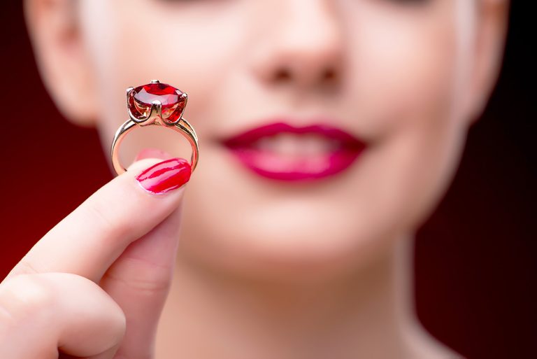 Γυναίκα δείνχει ένα δαχτυλίδι γάμου ή αρραβώνα με ρουμπίνι