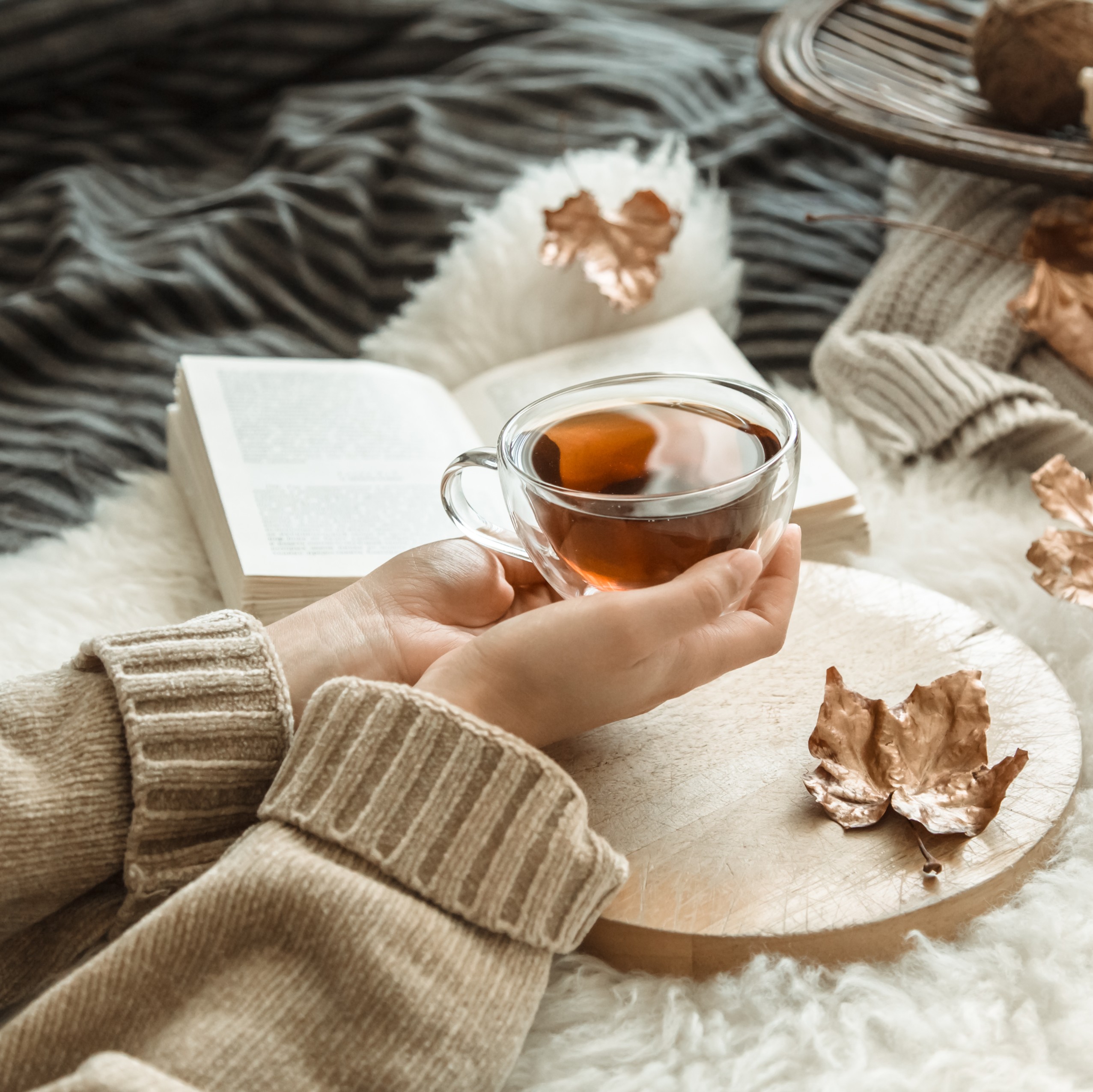 Γυναίκα πίνει τσάι και διαβάζει βιβλίο.