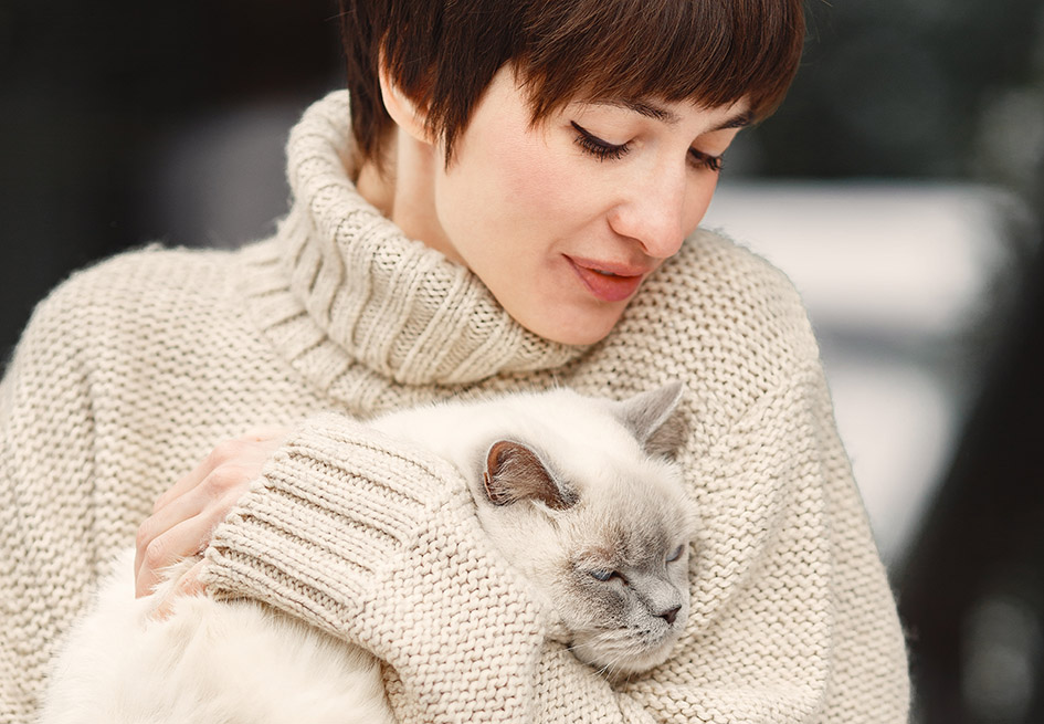 Ποια γάτα σάς ταιριάζει - Ράτσες γάτας για το σπίτι. Στη φωτογραφία γυναίκα κρατά γάτα στην αγκαλιά της.