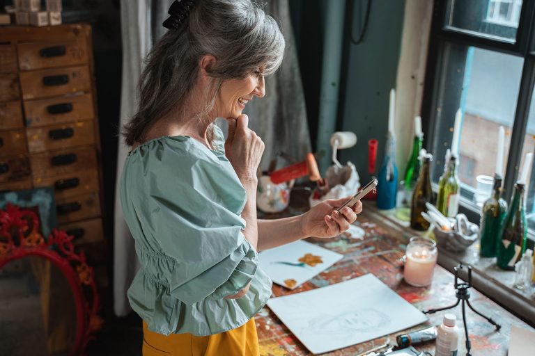 Δημιουργικότητα: Γυναίκα μέσης ηλικίας παρακολουθεί τον τρόπο για να βελτιώσει αυτό που δημιουργεί πάνω στον πάγκο εργασίας της.