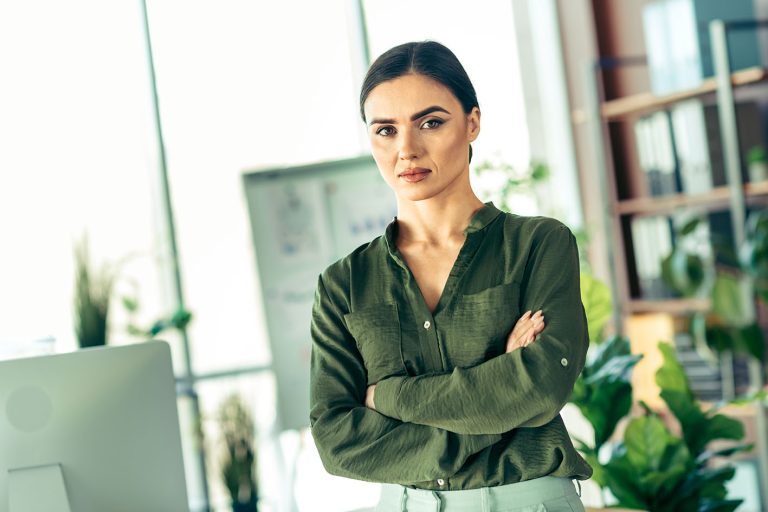 Γυναίκα στο γραφείο κοιτά τον φακό