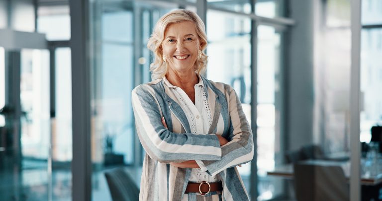 Γυναίκα στο γραφείο σίγουρη για τον εαυτό της χαμογελά.