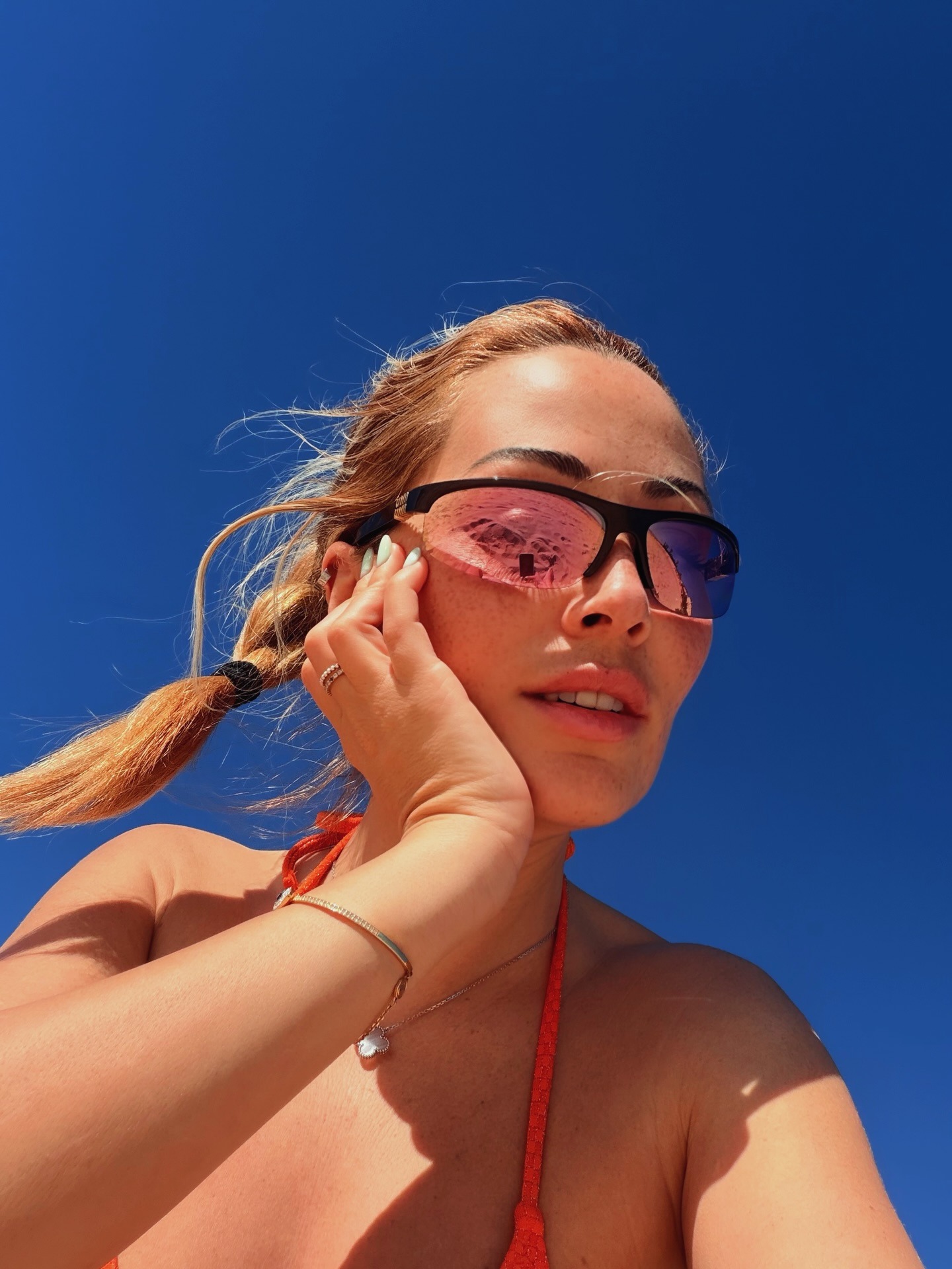 Η Ελένη Βουλγαράκη με μαγιό και γυαλιά ηλίου με φόντο τον γαλάζιο ουρανό