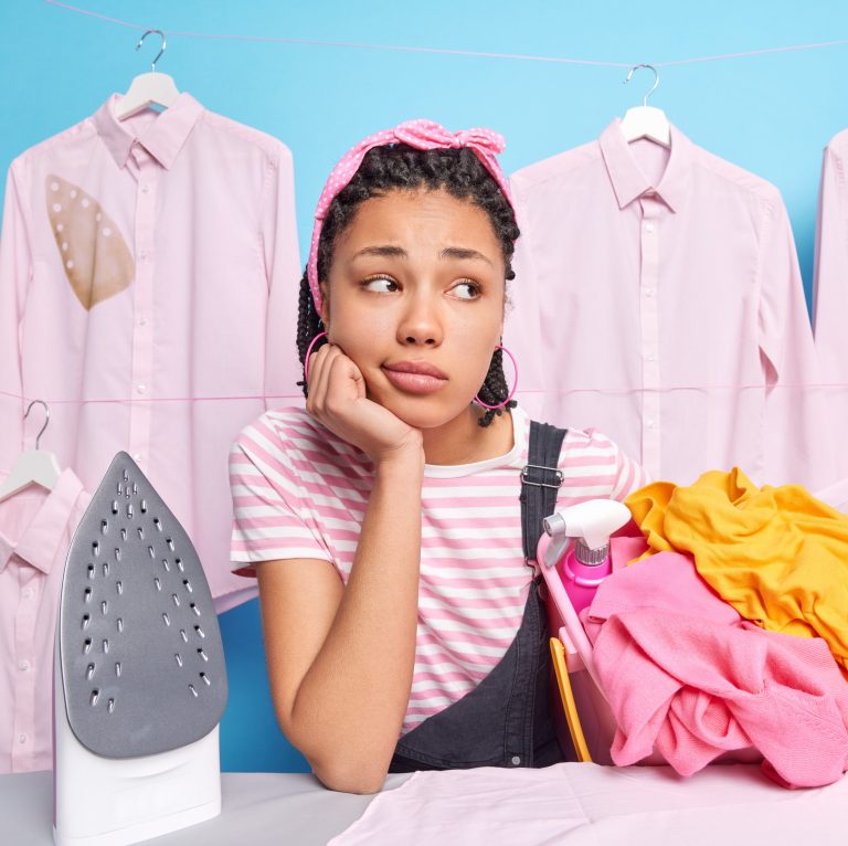 Γυναίκα σιδερώνει και το σίδερο αφήνει λεκέδες στα ρούχα.