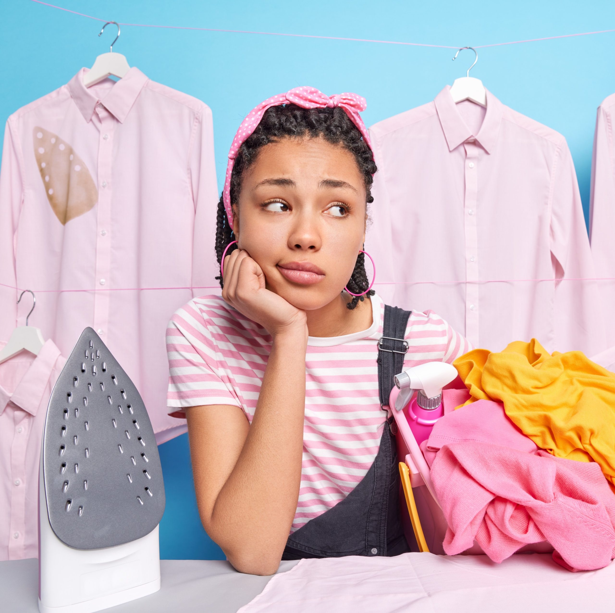 Γυναίκα σιδερώνει και το σίδερο αφήνει λεκέδες στα ρούχα.