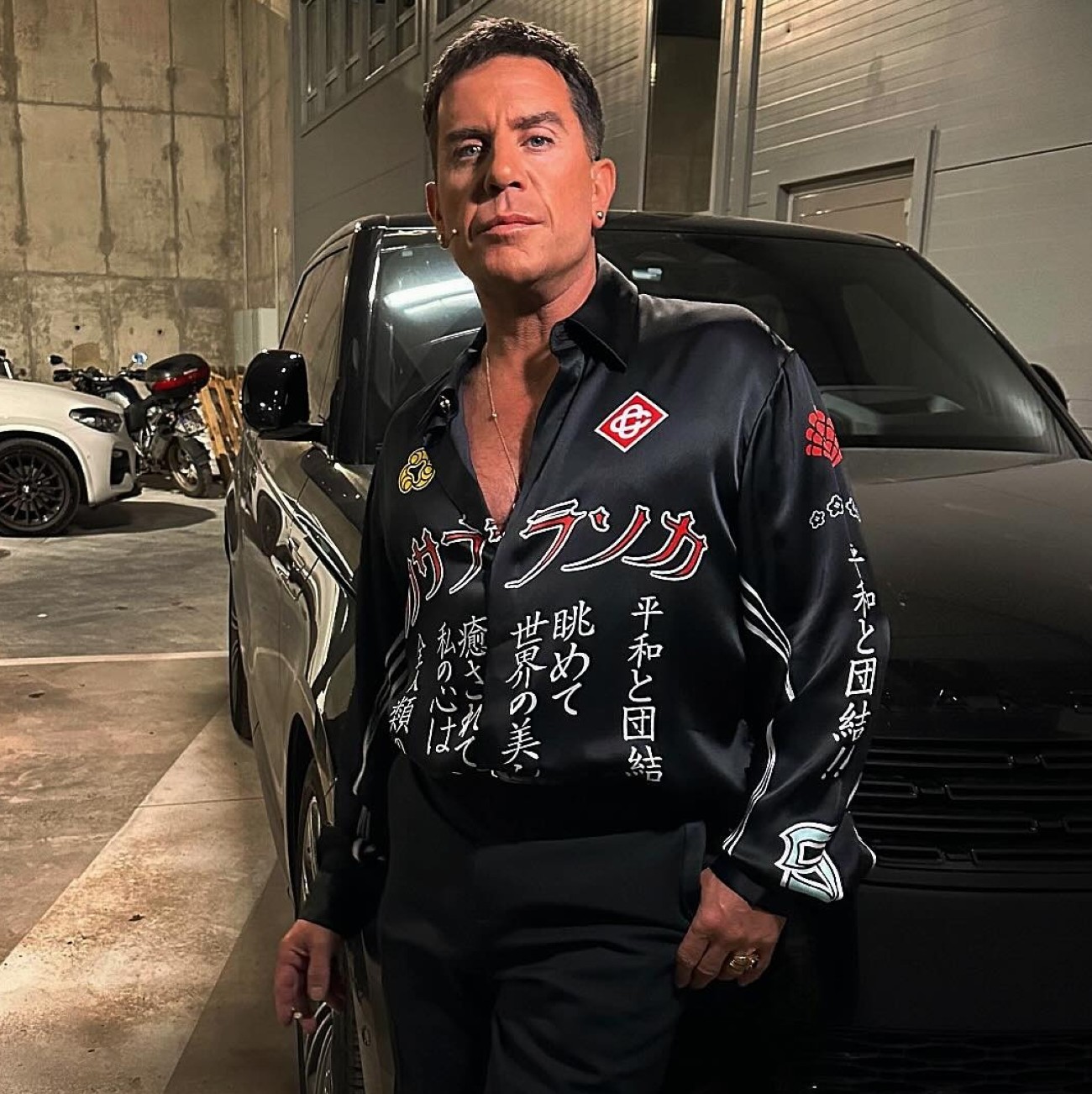 Ο Γιώργος Μαζωνάκης στέκεται μπροστά σε αυτοκίνητο