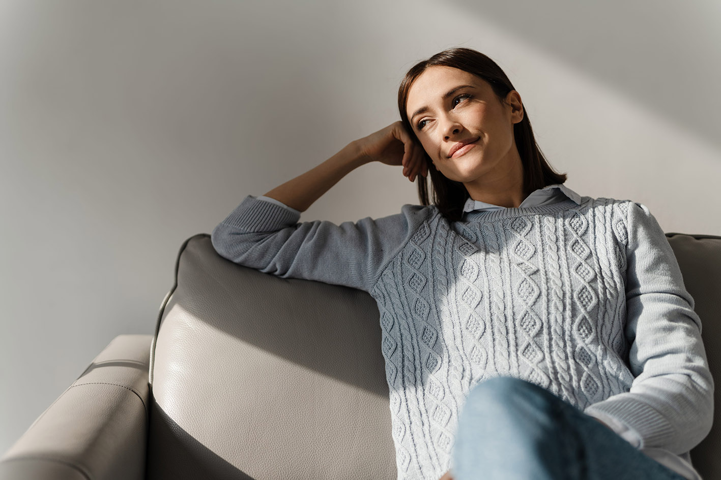 Ήρεμη γυναίκα στον καναπέ της χαμογελά