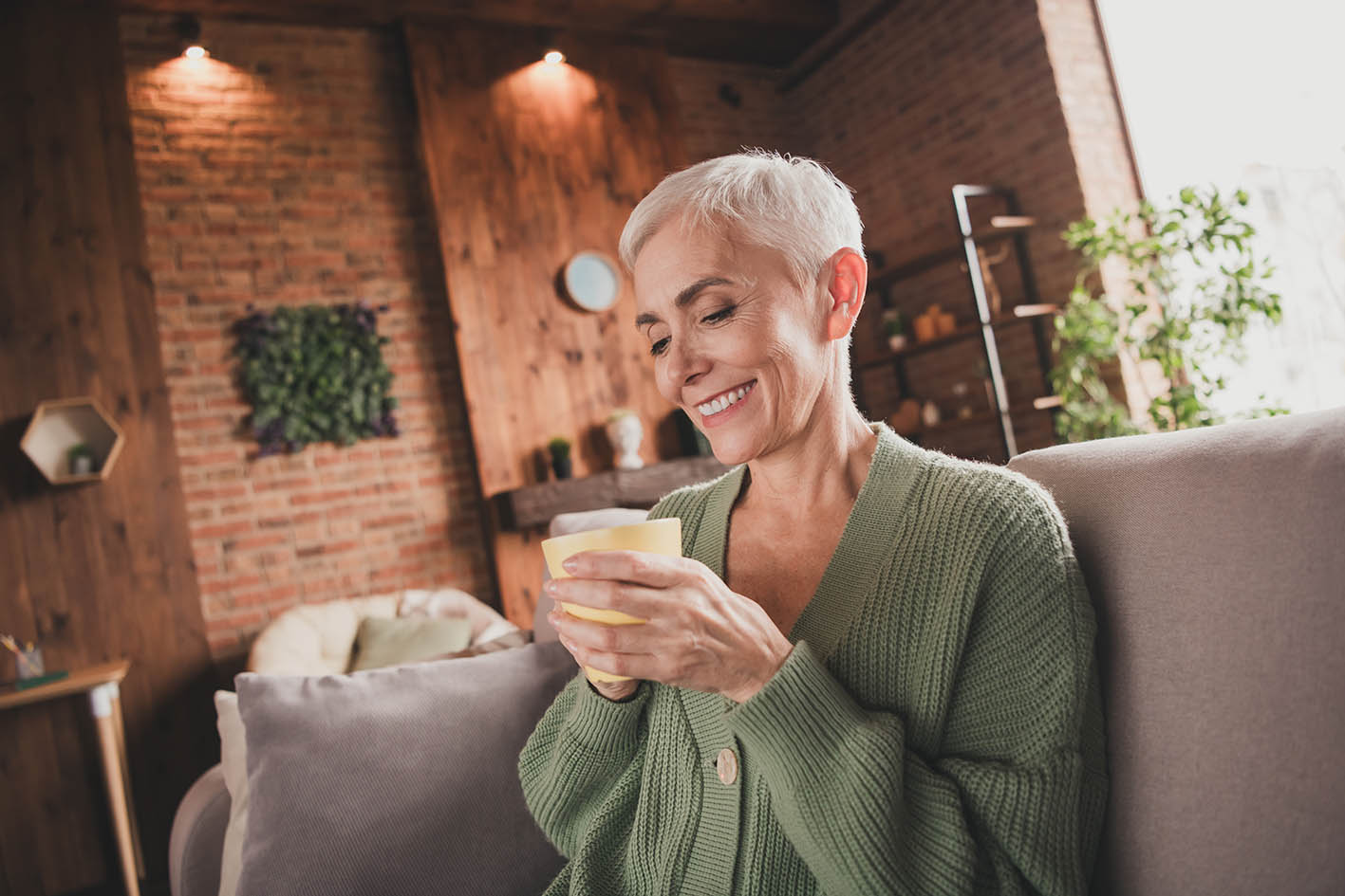 Γυναίκα μέσης ηλικίας κρατά τον καφέ της και χαμογελά