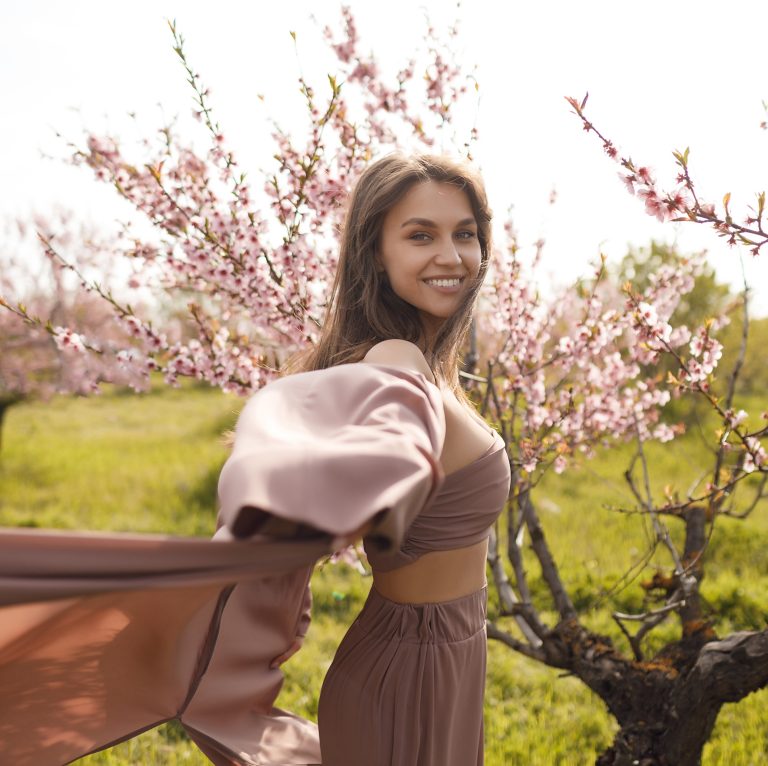 Νεαρή γυναίκα χαρούμενη ανάμεσα σε λουλούδια