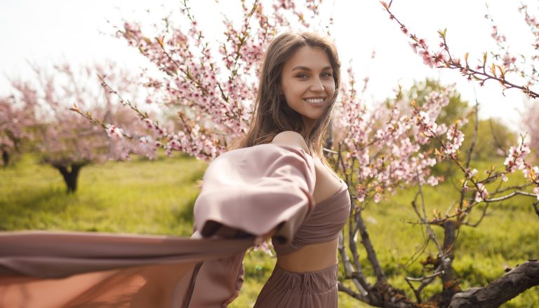 Νεαρή γυναίκα χαρούμενη ανάμεσα σε λουλούδια