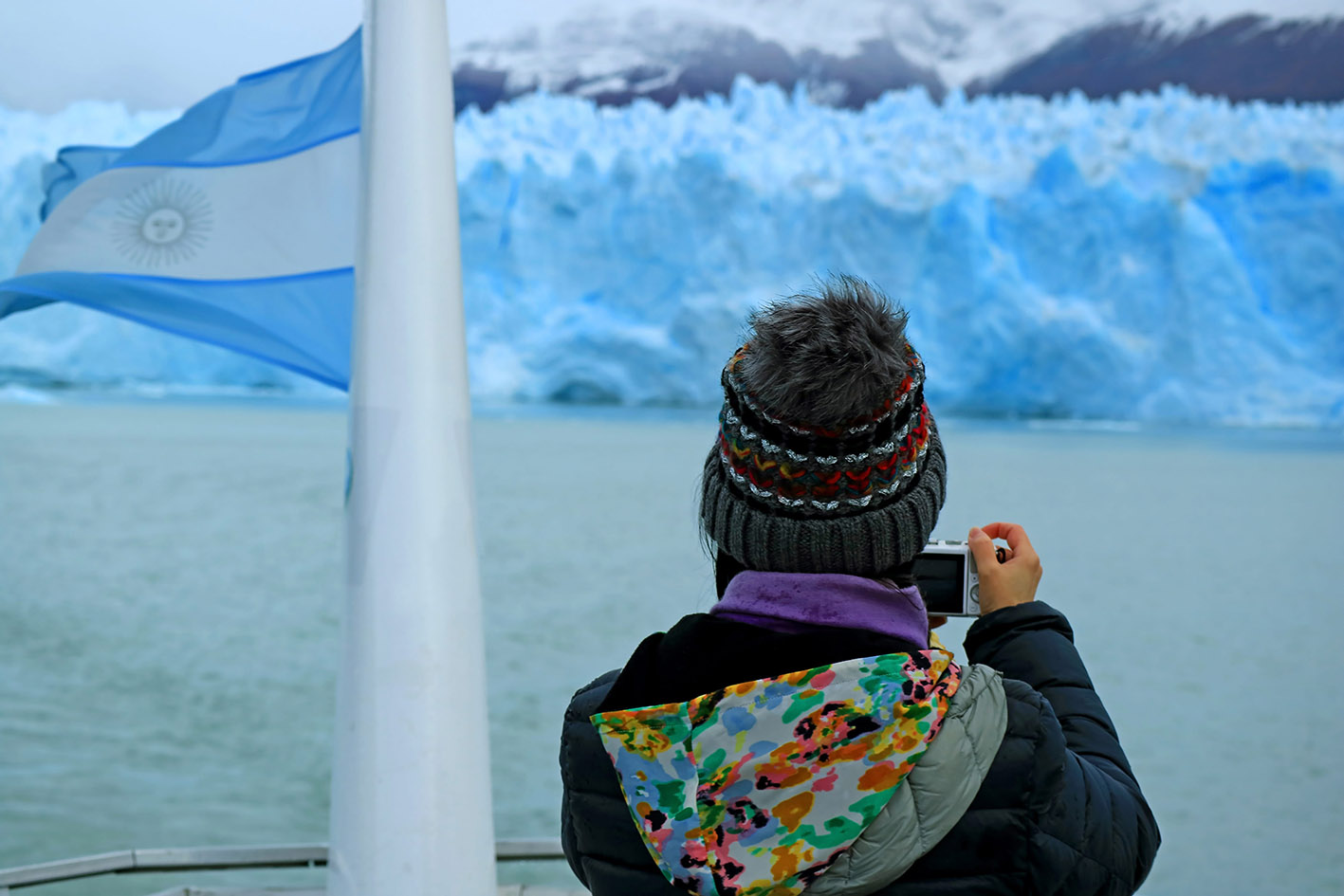 Το ice trekking πάνω στον Perito Moreno να προσφέρει μια σουρεαλιστική εμπειρία ανάμεσα σε γαλάζιους πάγους. Στη φωτογραφία γυναίκα τουρίστρια βγάζει φωτογραφίες τον εντυπωσιακό παγετώνα στην Αργεντινή.