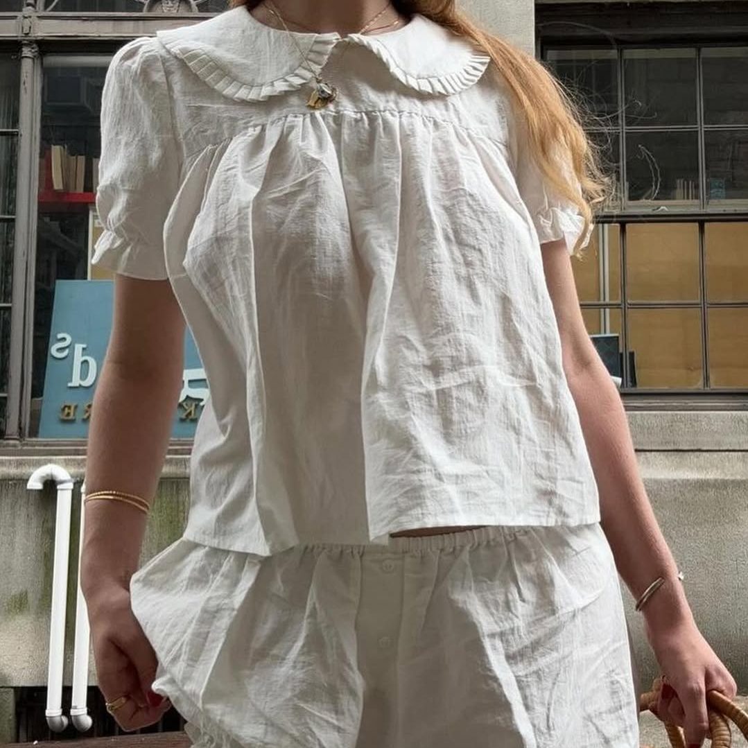 Κοπέλα που φοράει babydoll μπλούζα με ασορτί μίνι σορτς.