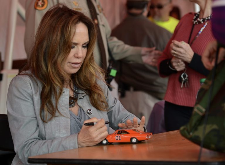 Η Catherine Bach των Dukes of Hazzard υπογράφει ένα μοντέλο του "General Lee" για έναν θαυμαστή στη διάρκεια επανασύνδεσης στο Old Middle Georgia Speedway του Byron της Τζόρτζια, 9 Μαρτίου 2013